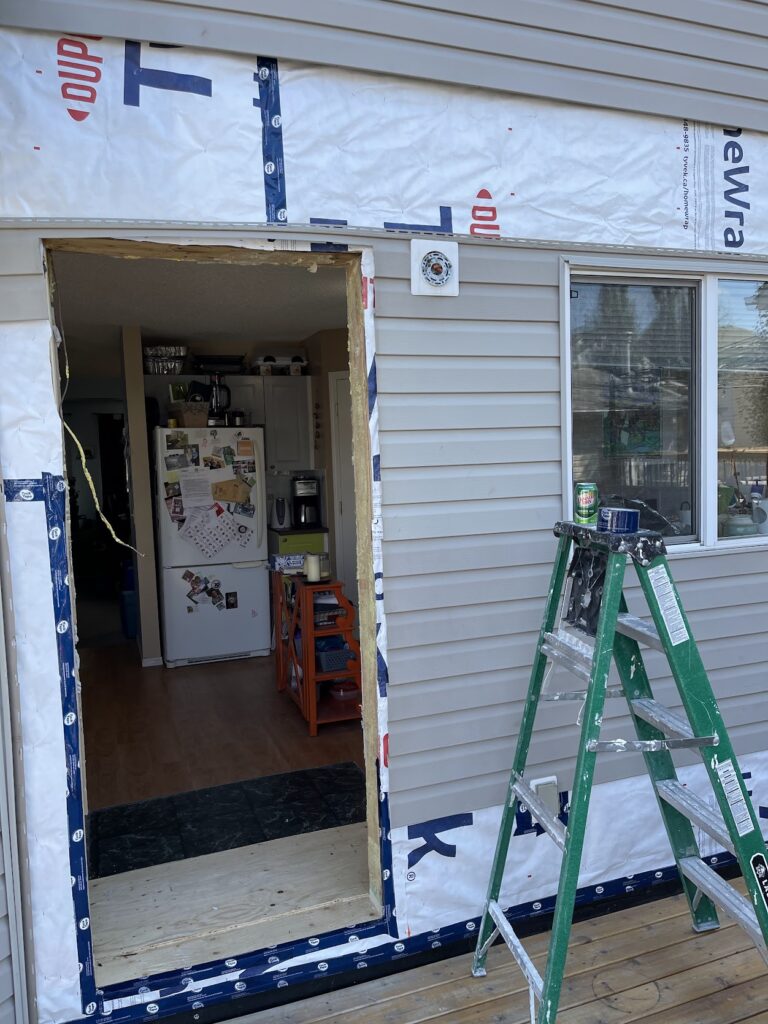 Exterior door opening prepared for repair and finishing on Calgary home