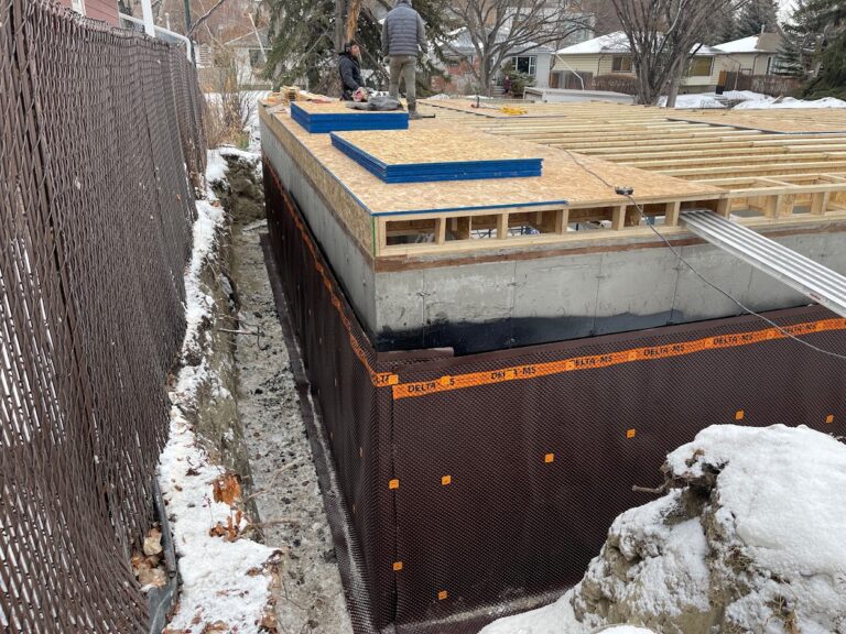 Exterior foundation wall construction work during a Calgary home addition project